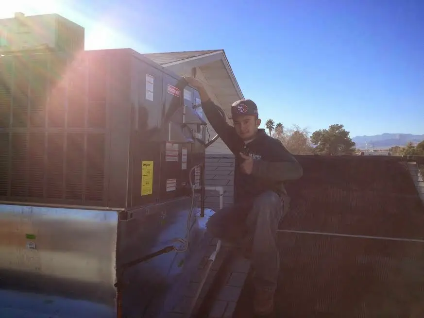 HVAC technician performing AC Tune-Up on a rooftop unit in Wildewood